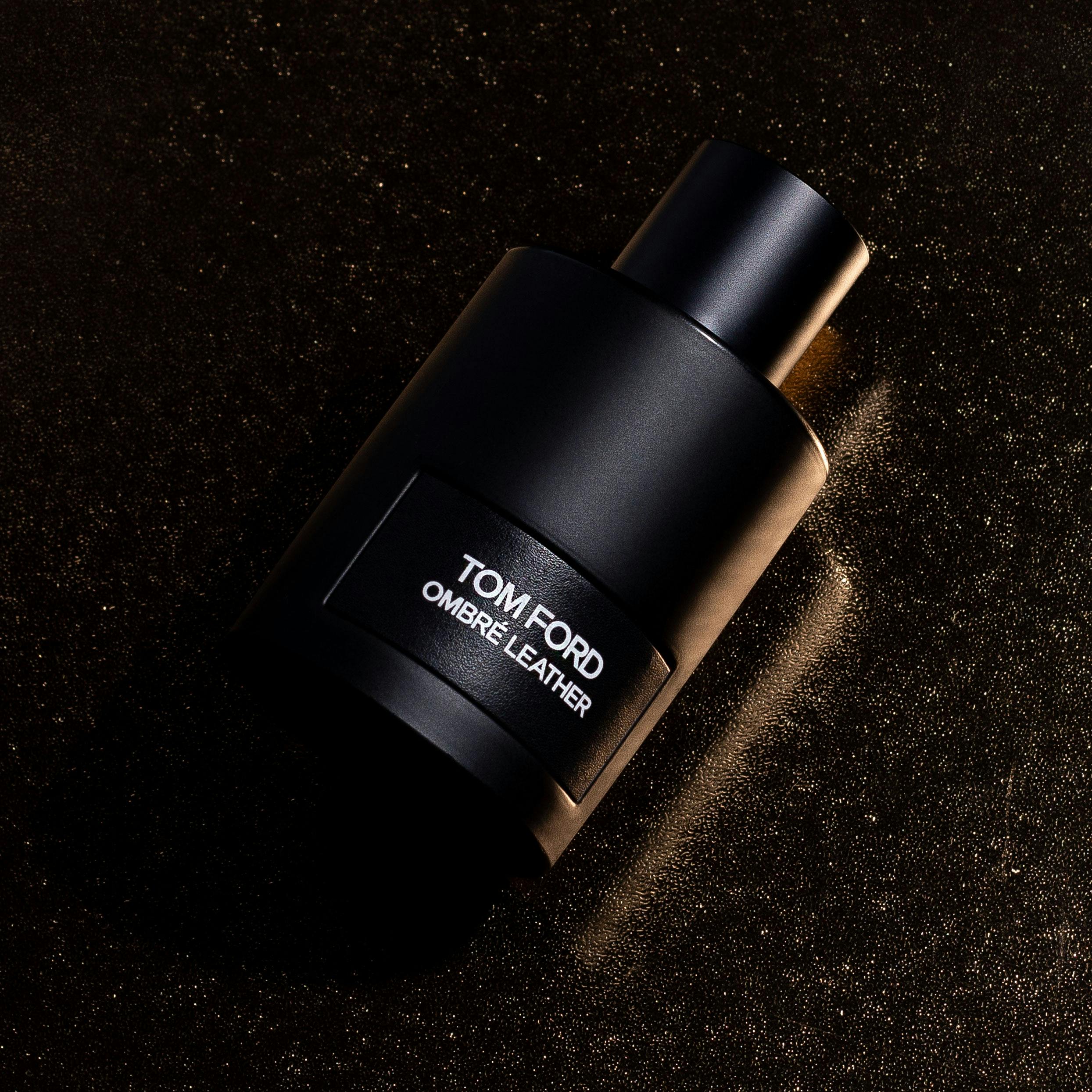 Elegant image of Tom Ford Ombre Leather fragrance bottle against a textured dark background.